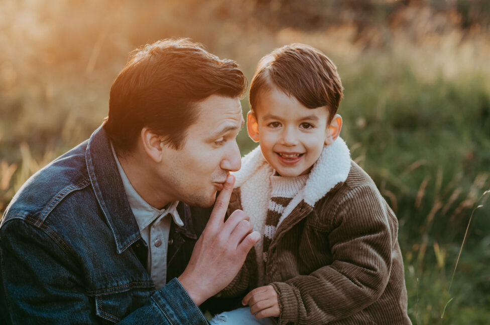 Papa und Sohn im Portrtait auf einer herbstlichen Wiese im Nachmittagslicht.