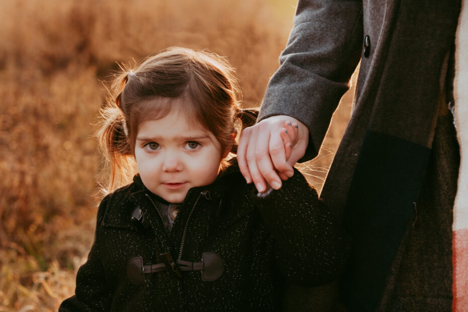 Kind an der Hand seiner Mama