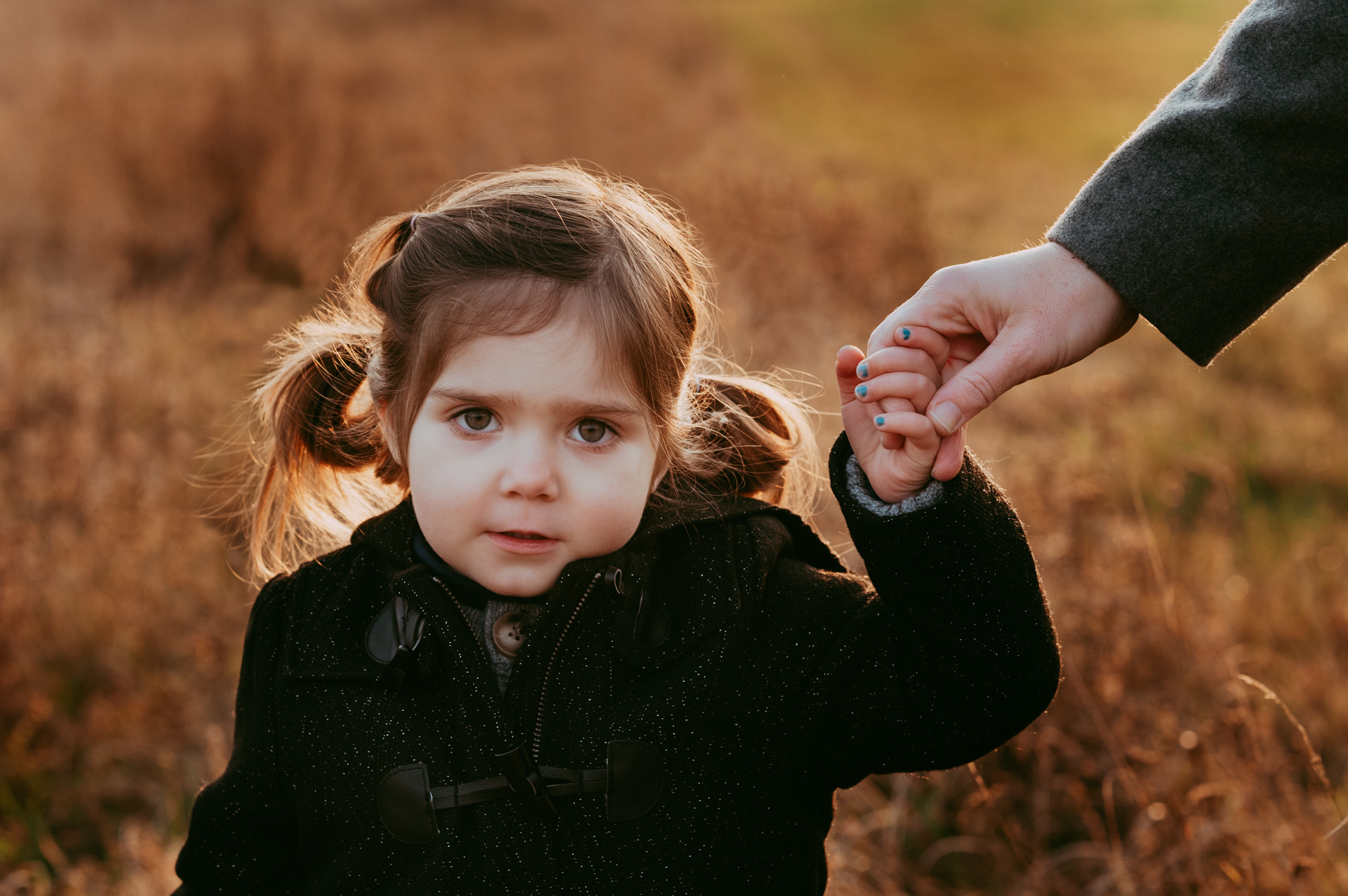 Kind an der Hand seiner Mama